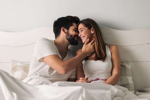 couple kissing in morning bed