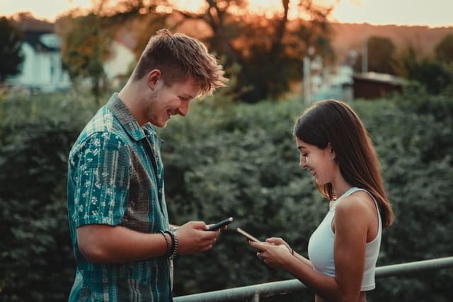 young couple texting outdoors