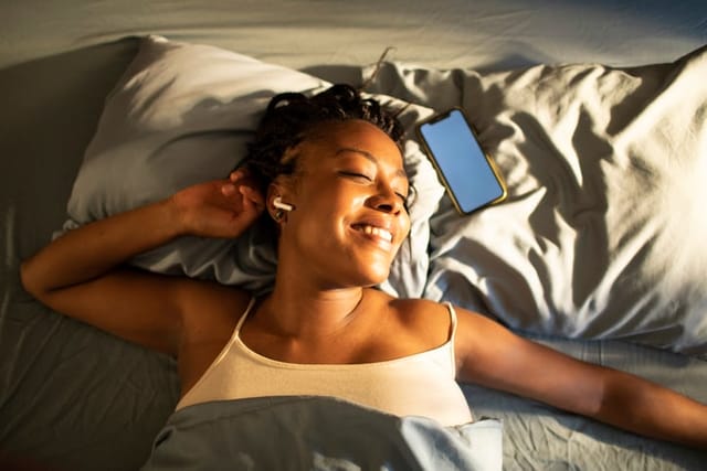 woman listening to music in bed