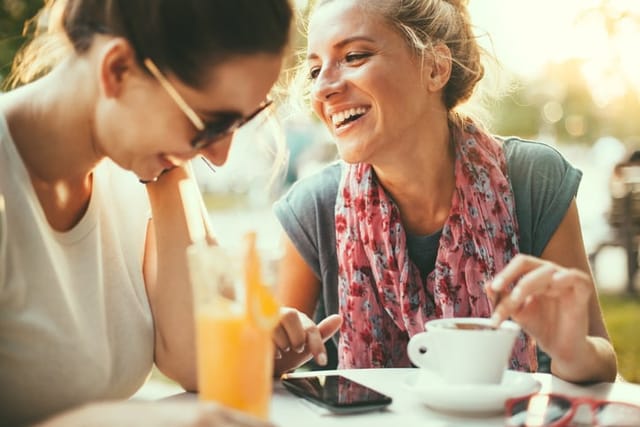 female friends laughing at cafe