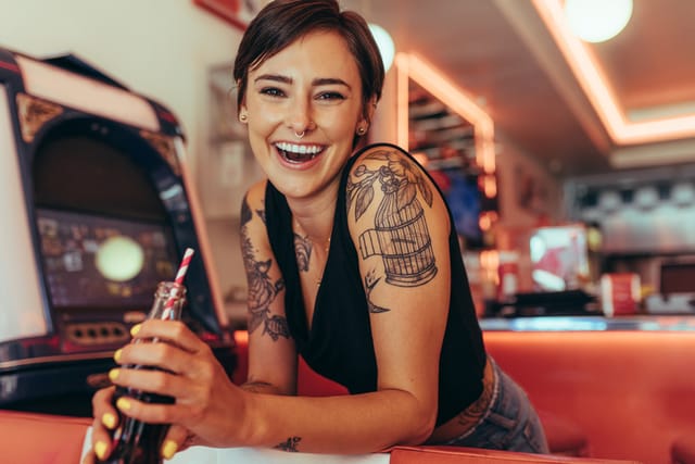 smiling woman drinking soda at diner
