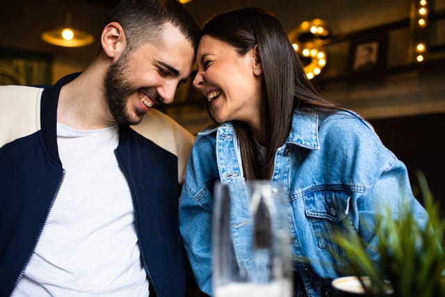 smiling couple touching foreheads on date