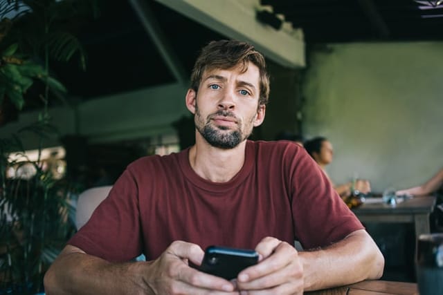 concerned man with phone looking at camera