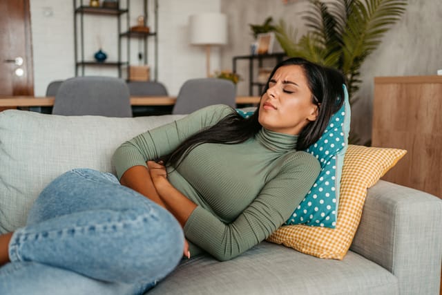 woman with cramps on couch
