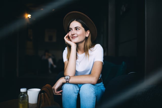 woman in hat smiling at cafe
