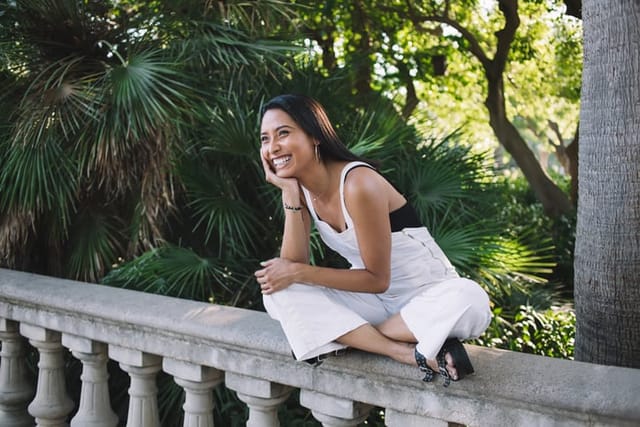 smiling woman sitting cross-legged outside
