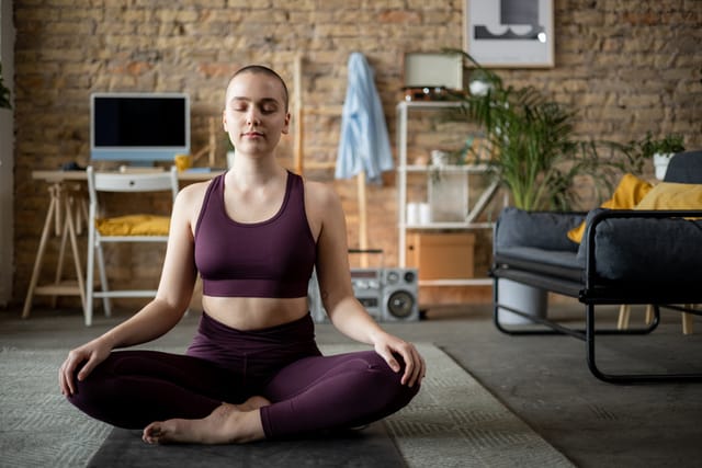 woman meditating quietly in apartment