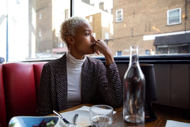 sad woman looking out cafe window