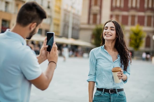 man taking woman's picture on vacation