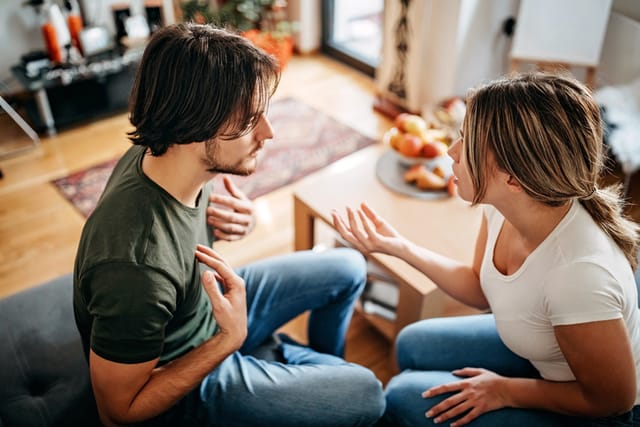 millennial couple arguing on couch