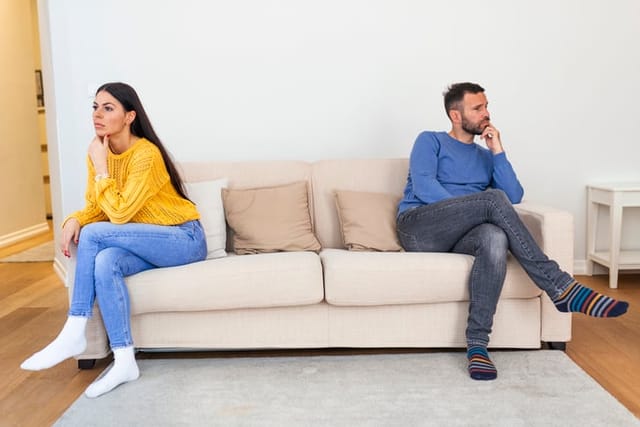 couple arguing opposite ends of couch