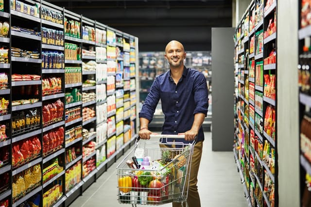 man smiling while grocery shopping