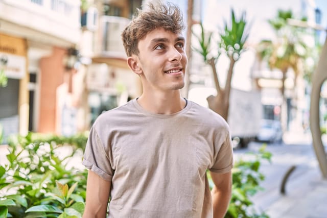 smiling millennial guy looking up