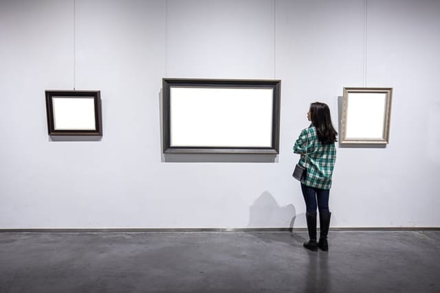 woman looking at blank paintings at museum