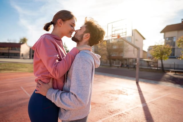 couple kissing on basketball court