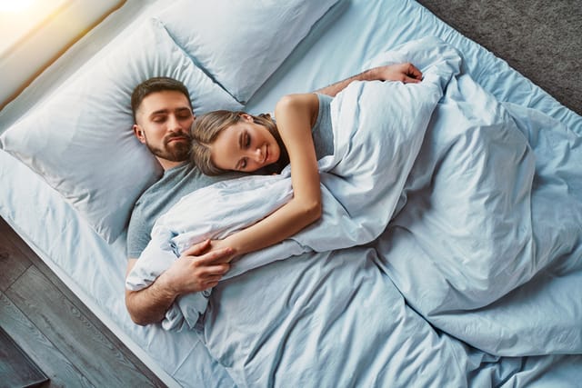 content couple cuddling in bed