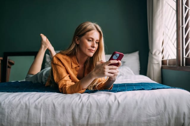 blonde woman texting in bed