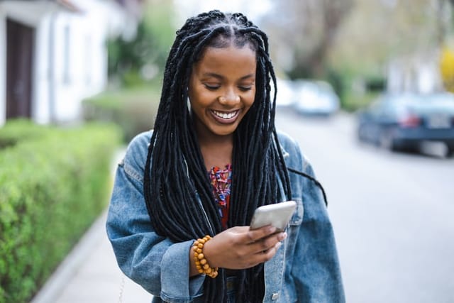 woman texting walking down street