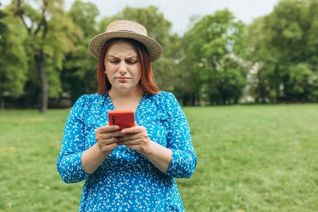 annoyed woman texting in park