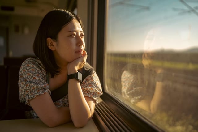 pensive woman looking out train window