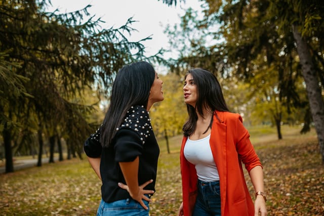 two female friends arguing in park