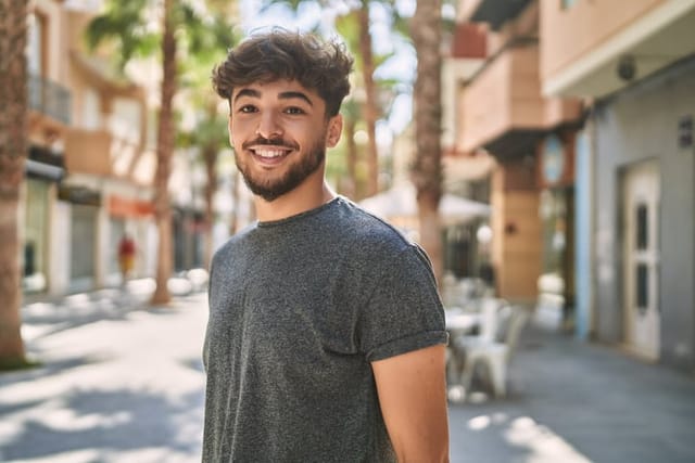 smiling millennial guy on sunny summer day