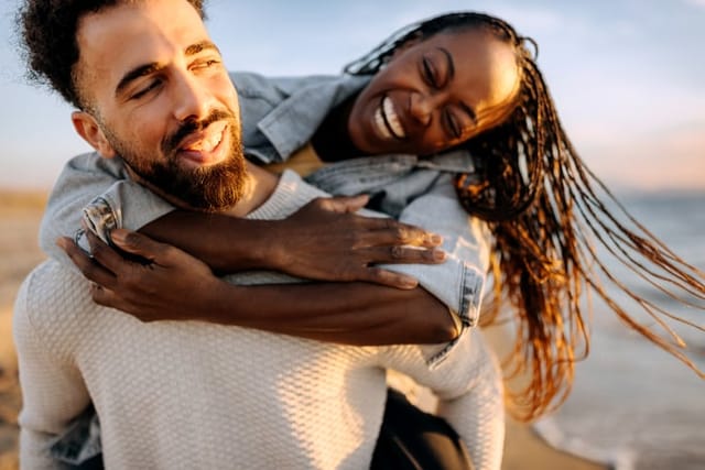 smiling happy couple on the beach at sunset