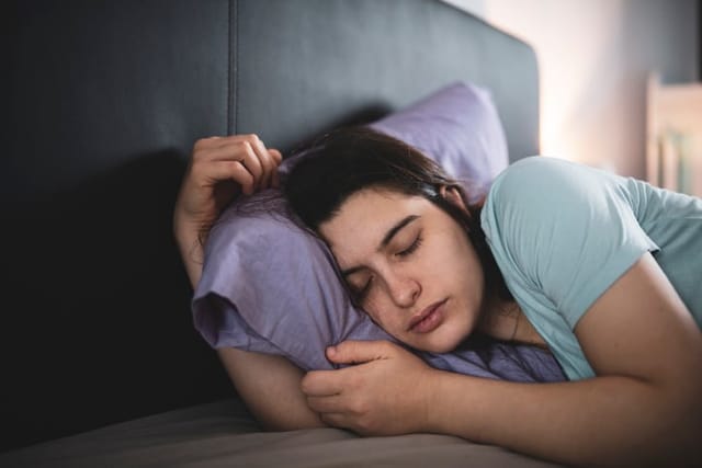 millennial woman sleeping in bed