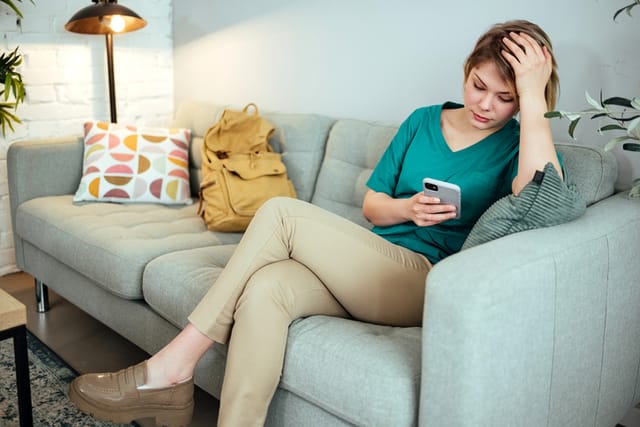 woman texting on couch