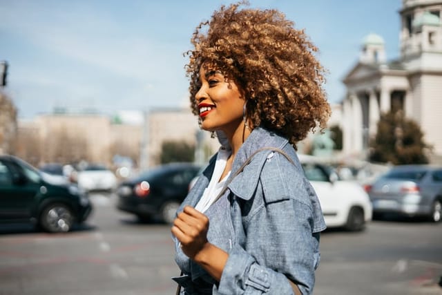 beautiful black woman walking through city
