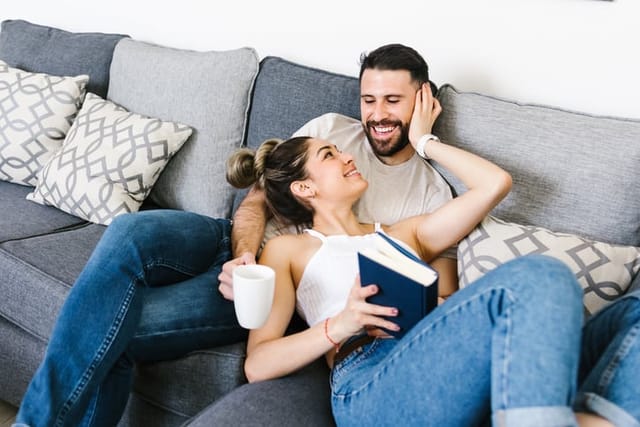 couple cuddling on couch at home