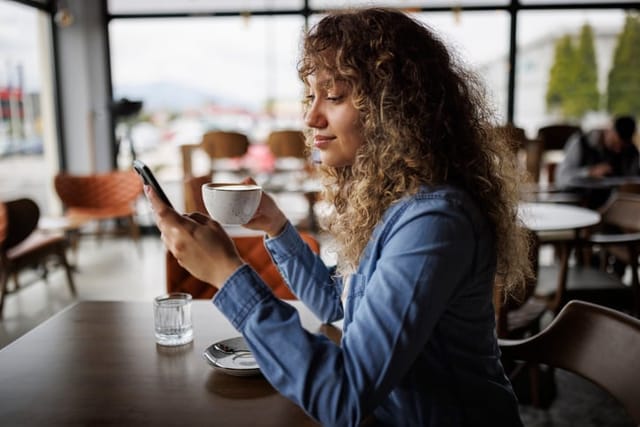 woman texting at coffee shop