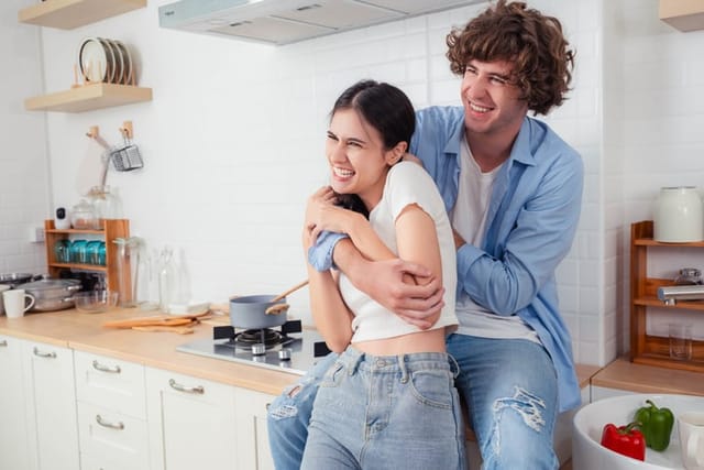 happy couple laughing in kitchen