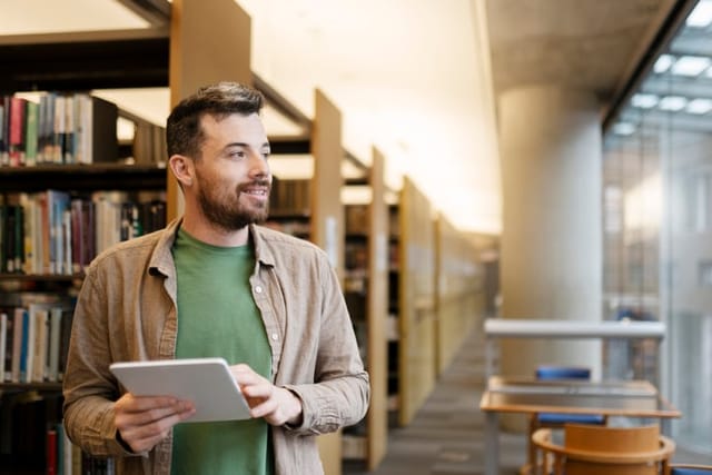 guy smiling in university library