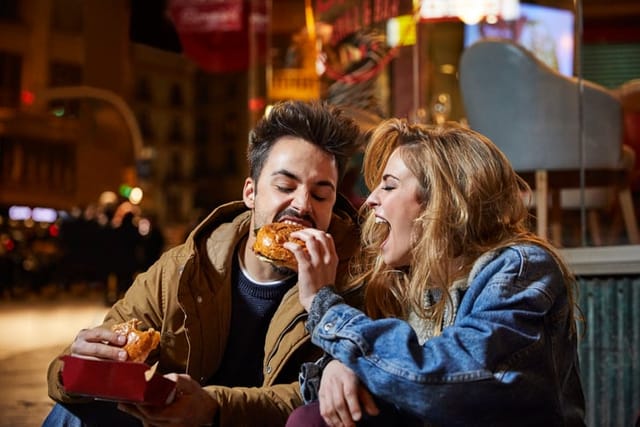 woman feeding boyfriend burger