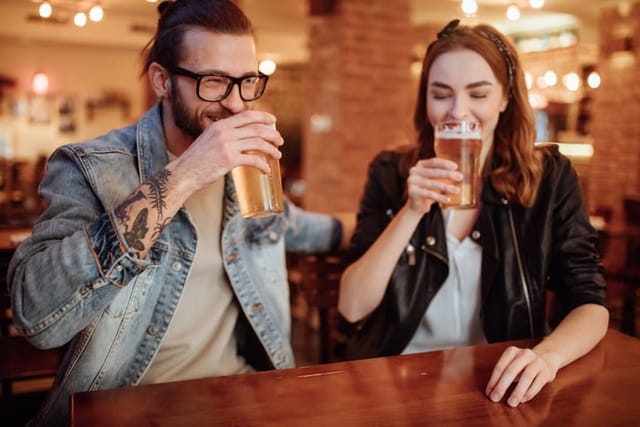 cute couple having beer at bar