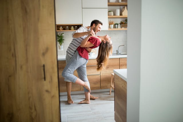 laughing couple dancing in kitchen