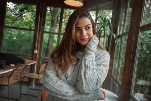 A portrait of a beautiful young woman in a cozy sweater.