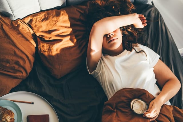 woman exhausted laying in bed