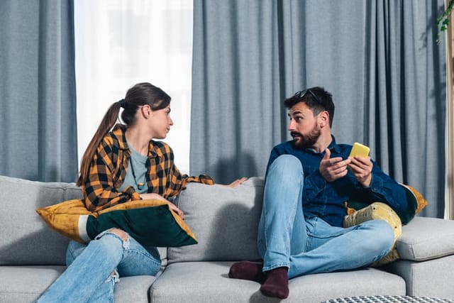 couple sitting on couch arguing