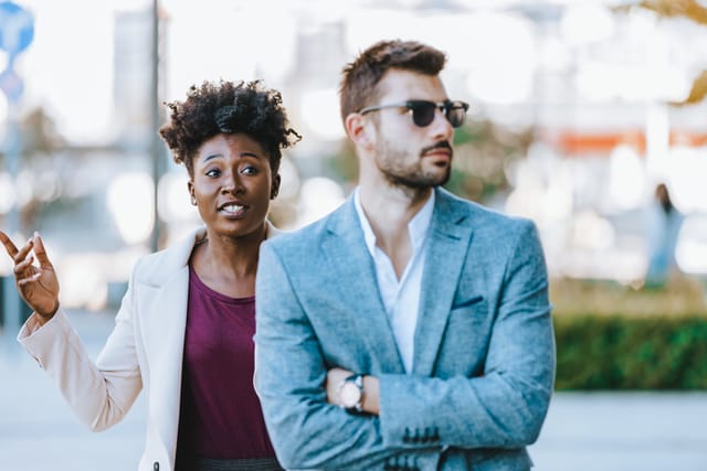 Sad young black woman and man outdoor on street having relationship problems