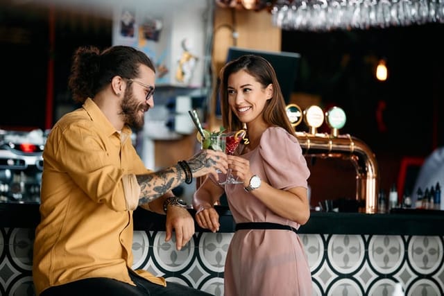 couple toasting drinks at bar