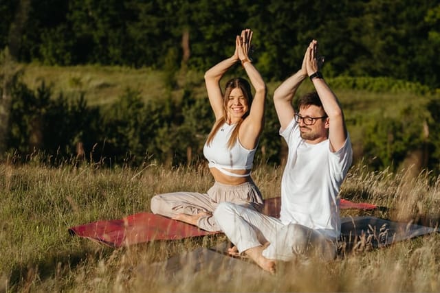 couple meditating in a field