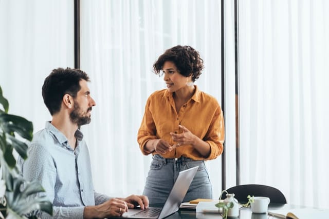 male and female colleague chatting in office