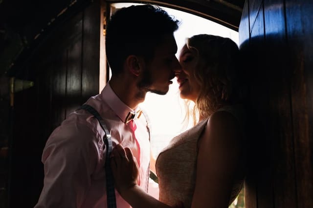 sharing a romantic kiss in the doorway