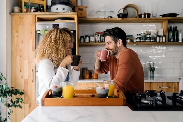 couple grabbing coffee in kitchen