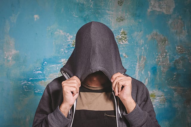 Shy young man closing his face