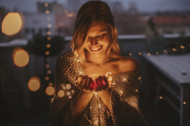 woman outside in christmas lights at night