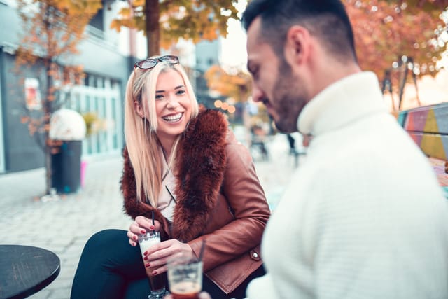 Blond Female Enjoying Coffee Discussion With Boyfriend Outside