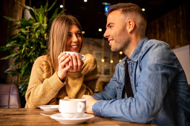 Happy couple talking and flirting on a coffee shop